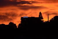 a building with a sign on top of it at sunset at Pousada Colina Da Neve in São Joaquim