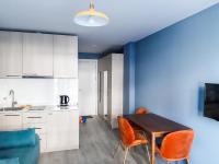 a kitchen with a wooden table and orange chairs at new Gudauri 214 in Gudauri
