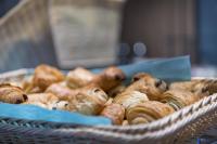 una cesta de donuts y bollería en una mesa en Holiday Inn Express - Luzern - Kriens by IHG, en Lucerna