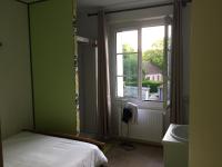 a bedroom with a bed and a window and a sink at Hôtel du Cygne in LʼAigle