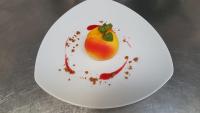 a white plate with a peach on it at Hôtel du Cygne in LʼAigle