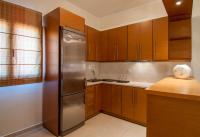 a kitchen with wooden cabinets and a stainless steel refrigerator at Kyniska Hotel in Plytra