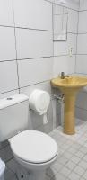 a white bathroom with a toilet and a sink at JR Hotel in João Pessoa