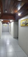 an empty hallway with white floors and a painting on the wall at JR Hotel in João Pessoa