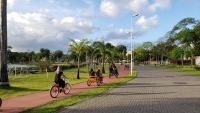 a group of people riding bikes down a street at JR Hotel in João Pessoa