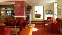a living room with red furniture and red chairs at Hollins Hall Hotel, Spa & Golf in Bradford
