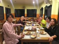 Un grupo de personas sentadas alrededor de una mesa comiendo comida en Sweet Home, en Chitwan