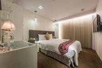 a bedroom with a bed and a desk with a lamp at Forward Hotel Taipei Nangang in Taipei