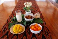 a table topped with bowls of fruit and glasses of milk at Pavilla Labuan Bajo in Labuan Bajo