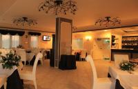 Un comedor con mesas blancas y sillas blancas. en Hotel Madonna Delle Grazie, en Ceglie Messapica