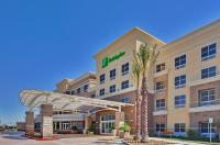 a hotel with a palm tree in front of it at Holiday Inn Ontario Airport - California by IHG in Ontario