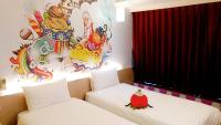 two beds in a room with a painting on the wall at Morwing Hotel Fuzhong in Taipei