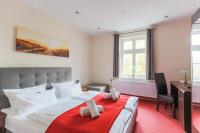 a bedroom with a large white bed with a red blanket at Hotel &amp; Restaurant ,,Zur Alten Oder&quot; in Frankfurt-Oder in Frankfurt Oder