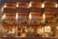 Un edificio con mesas y sillas delante. en Hotel Le Monal, en Sainte-Foy-Tarentaise