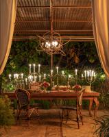 Una mesa de comedor con velas y una lámpara de araña. en Petit Ermitage, en Los Ángeles