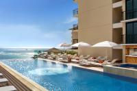 ホノルルにあるHalepuna Waikiki by Halekulani - NO RESORT FEEのホテルのスイミングプール(椅子付)と海