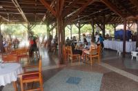 een groep mensen die aan tafels in een restaurant zitten bij Charlestina Beach Resort in Ampeni