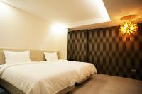 a bedroom with a large white bed and a chandelier at The Fantasy Apartment in Hualien City