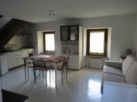 a kitchen and dining room with a table and a couch at Maison Jasmine in Aosta