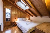 a bedroom with a large white bed in a wooden ceiling at Apartment Capucin in Chamonix