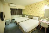 a hotel room with two beds and a tv at Ximen Relite Hotel in Taipei