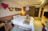 a hotel room with a bed with a stuffed animal on it at Ximen Relite Hotel in Taipei