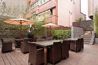 an outdoor patio with tables and chairs and umbrellas at Green World JianPei in Taipei