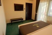 a hotel room with a bed and a flat screen tv at Magus Hotel in Baia Mare