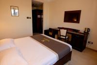 a bedroom with a bed and a desk with a computer at Magus Hotel in Baia Mare