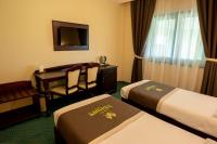 a hotel room with two beds and a desk at Magus Hotel in Baia Mare