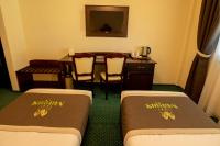 a hotel room with two beds and a table at Magus Hotel in Baia Mare