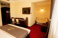 a hotel room with a bed and a chair and a table at Magus Hotel in Baia Mare