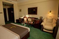 a hotel room with a bed and a table and chairs at Magus Hotel in Baia Mare