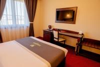 a hotel room with a bed and a desk and a computer at Magus Hotel in Baia Mare