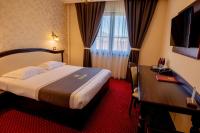 a hotel room with a bed and a desk at Magus Hotel in Baia Mare