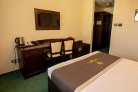 a hotel room with a bed and a desk with a computer at Magus Hotel in Baia Mare