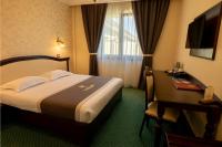 a hotel room with a bed and a desk at Magus Hotel in Baia Mare