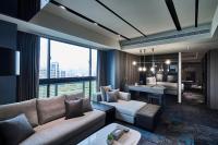 a living room with a couch and a table in a room at Kung Shang Design Hotel in Kaohsiung