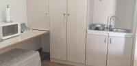 a kitchen with white cabinets and a sink and a microwave at Ladera - Vista Self-catering Guesthouse in Paarl