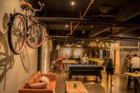 una bicicleta colgada en una pared sobre una mesa de ping pong en Bed Attitude Hostel Cenang, en Pantai Cenang