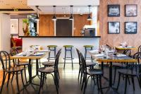 een restaurant met houten tafels en groene krukken bij Novotel Paris 17 in Parijs