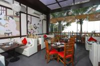 uma sala de jantar com mesas e cadeiras em um restaurante em Queenco Hotel & Casino em Sihanoukville