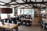 een eetkamer met houten tafels en stoelen bij Olmenduin Chalet Olm Zeeland in Serooskerke