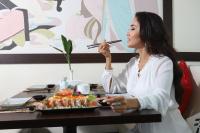 uma mulher sentada à mesa com um prato de comida em Queenco Hotel & Casino em Sihanoukville