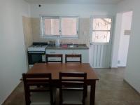 una cocina con mesa de madera y sillas. en Departamento Colón 1, en San Rafael
