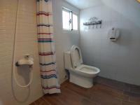 a bathroom with a toilet and a shower curtain at Hejia B&amp;B in Hualien City