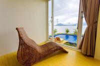 a rattan chair in a room with a view of a pool at Sheng Tu Villa in Hengchun South Gate