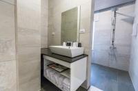 a bathroom with a white sink and a shower at Sheng Tu Villa in Hengchun South Gate