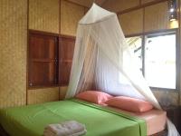 a bed with a mosquito net in a room at Malibu Beach Bungalows in Chaloklum
