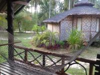 a hammock in front of a small building at Malibu Beach Bungalows in Chaloklum